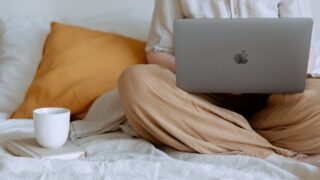 anonymous woman using laptop in bedroom