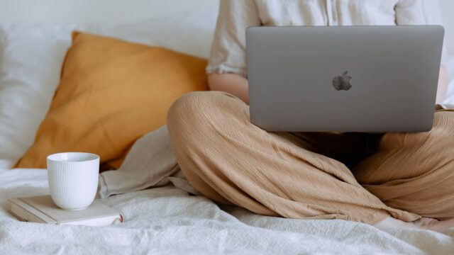 anonymous woman using laptop in bedroom